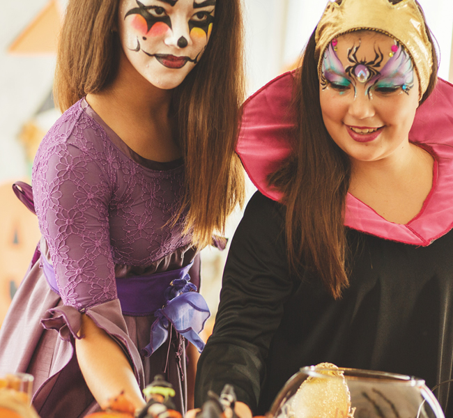 Two female teenagers in costume with face paint