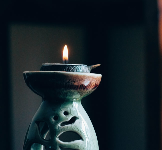Green ceramic candleholder with lit candle