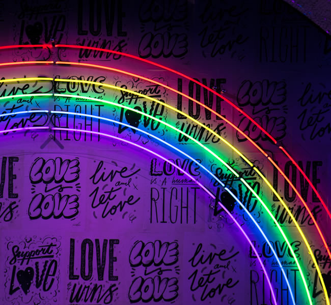 Neon tube rainbow and words on black background