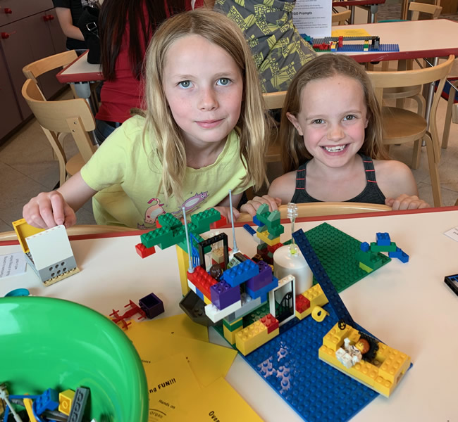 Two girls building with Legos