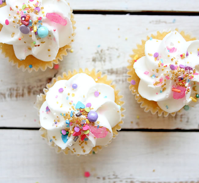 3 small white cupcakes with white icing/sprinkles